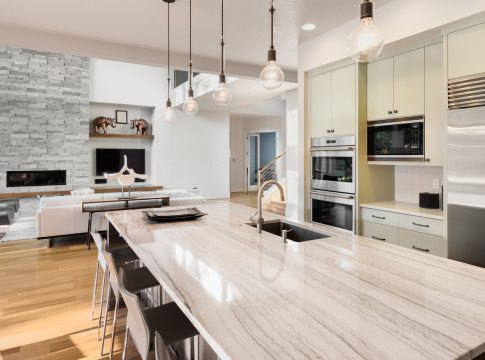 Urban Kitchen with Granite Tops, Exposed Bulb Lights and Island Portal