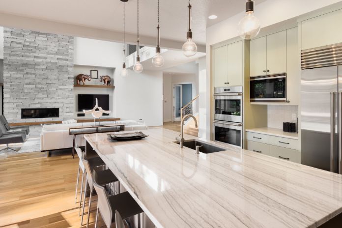 Urban Kitchen with Granite Tops, Exposed Bulb Lights and Island Portal